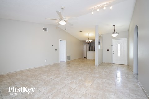 the living room is spacious and has a ceiling fan