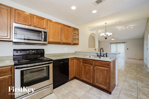 a kitchen with black appliances and wooden cabinets and a sink