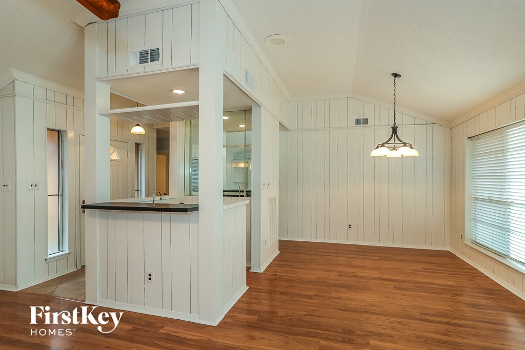 A spacious room with wooden floors and white walls.