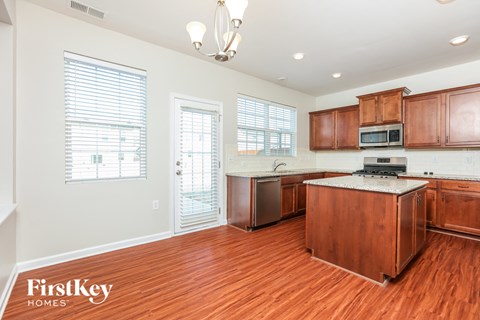 A kitchen with wooden cabinets and a white island.