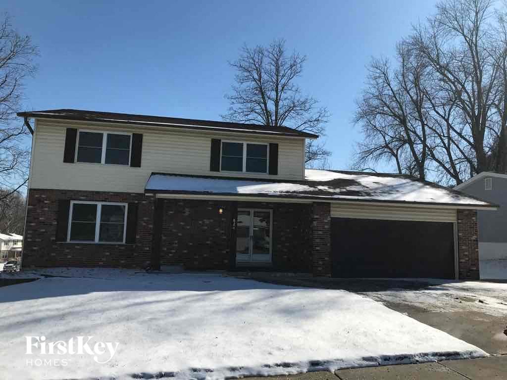A house with a snow-covered ground in front of it.