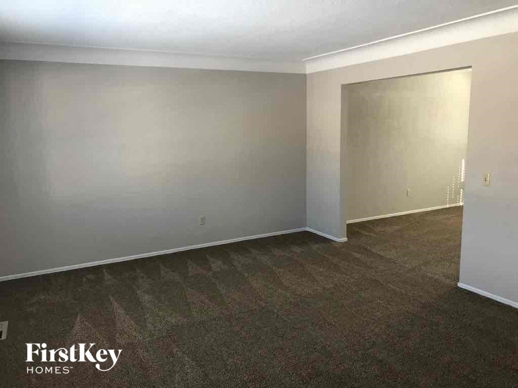 A room with a carpeted floor and a door on the right side.
