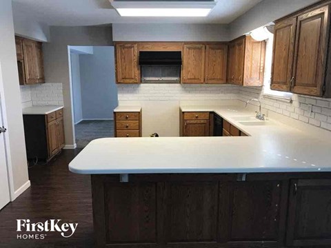 A kitchen with wooden cabinets and a white countertop.