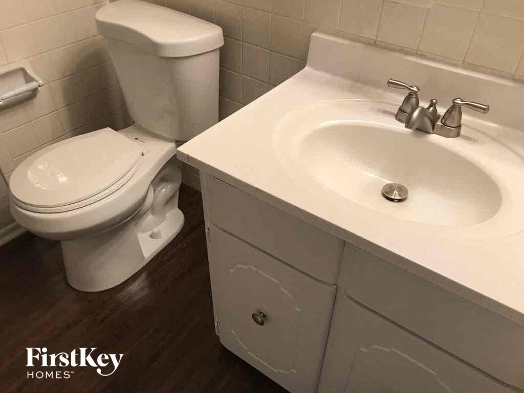 A white toilet and sink in a bathroom.