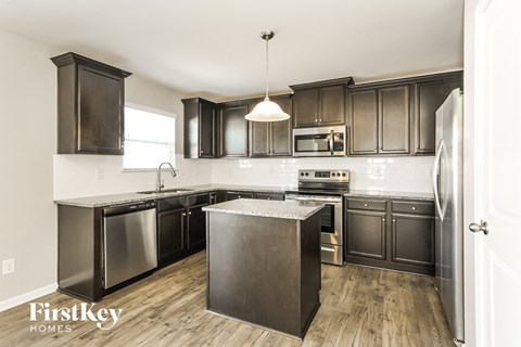 A kitchen with dark wood cabinets and stainless steel appliances.