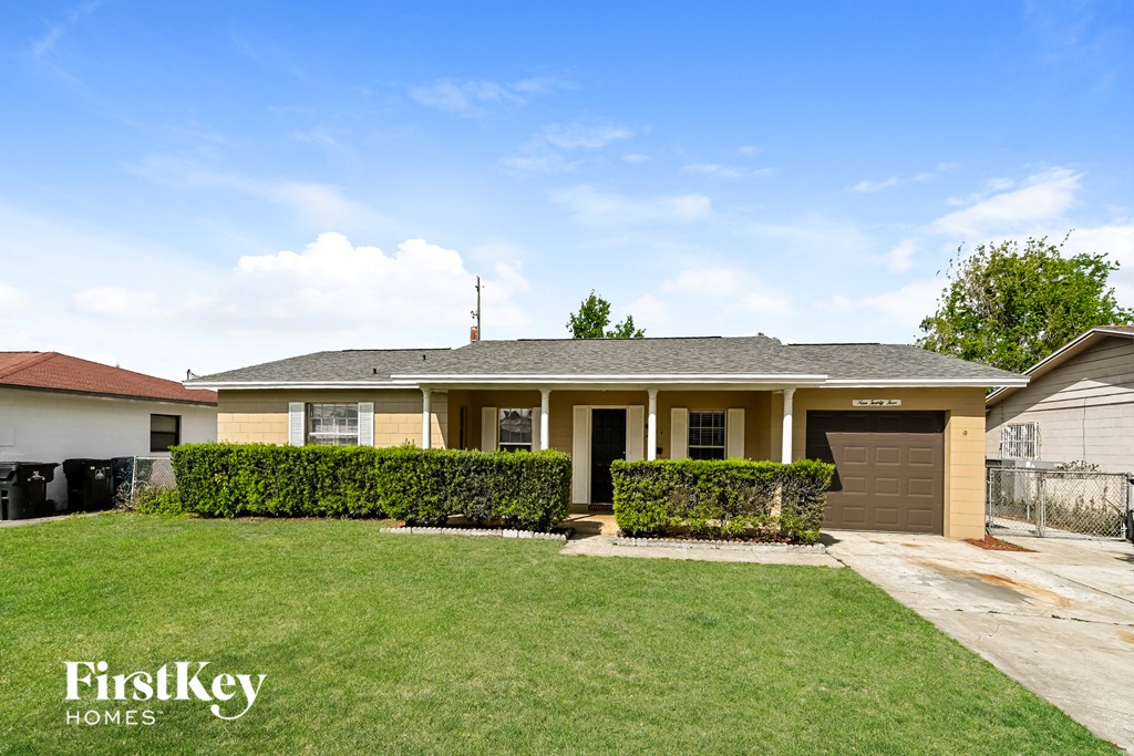 A house with a well-maintained lawn and a clear sky above.