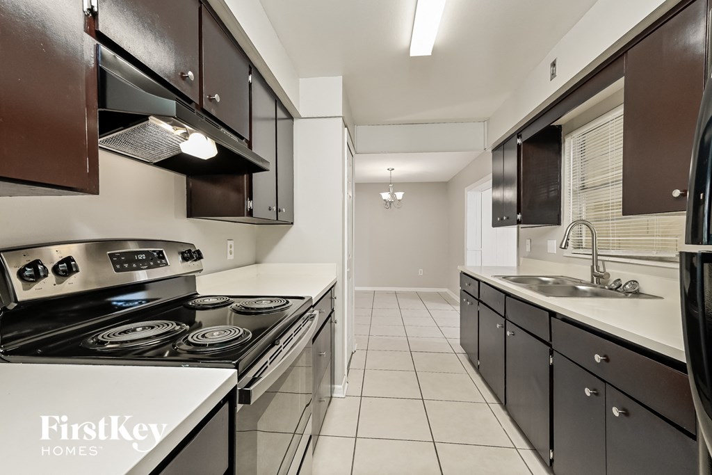 A kitchen with a stove top oven and a sink.