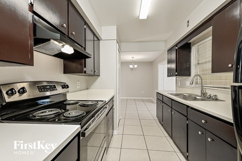 A kitchen with a stove top oven and a sink.