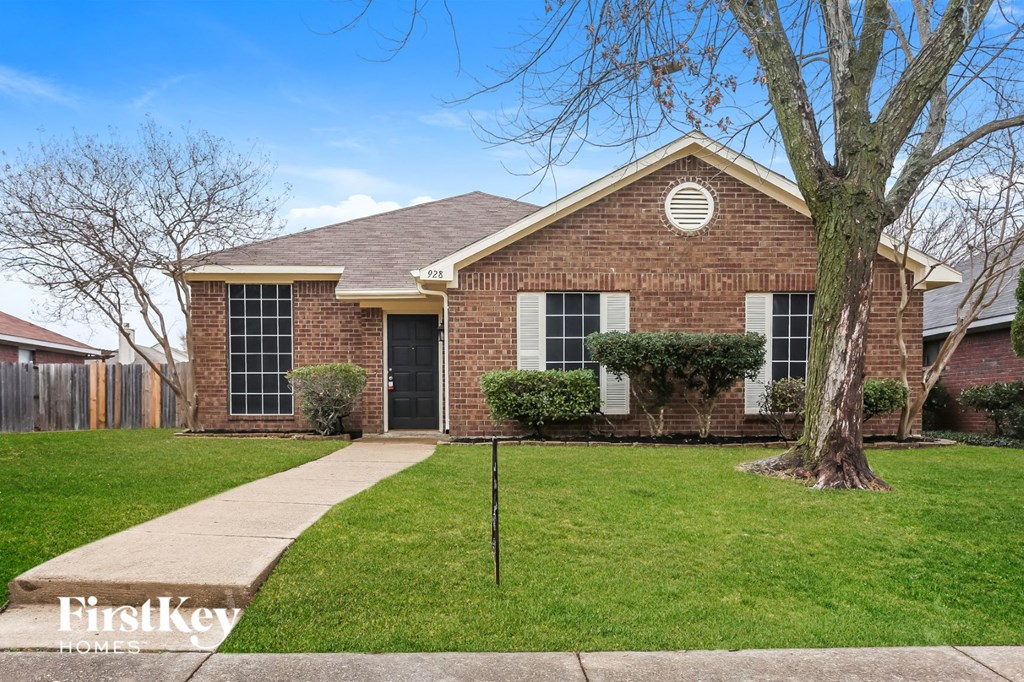 a small brick house with a yard and a tree