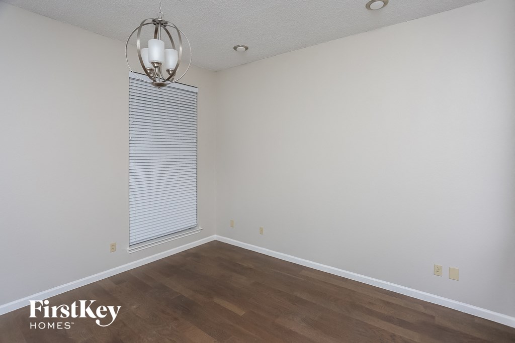 the living room of an empty house with wooden floors and a window