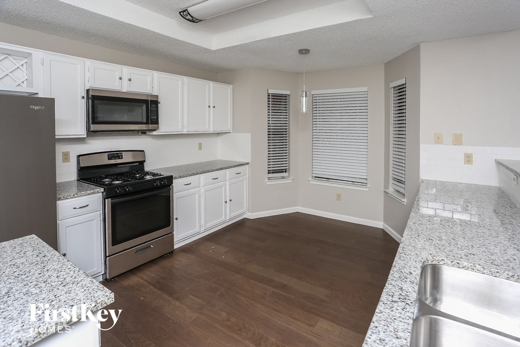 a kitchen with white cabinets and stainless steel appliances