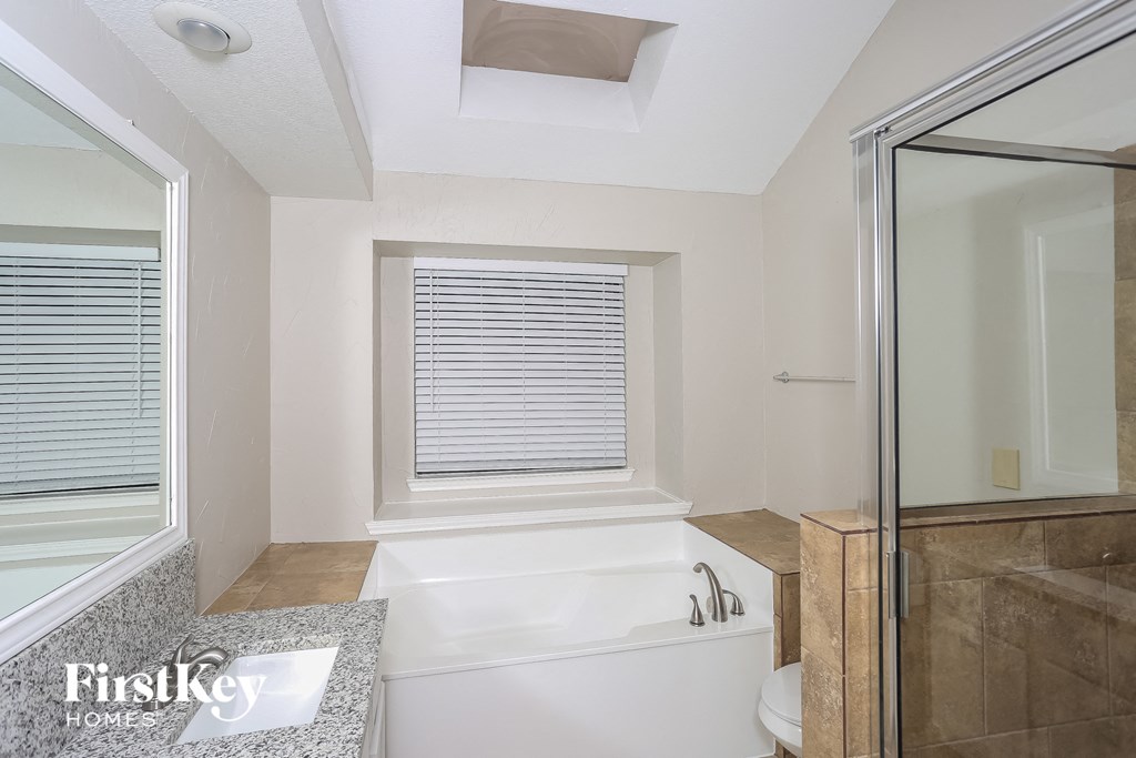 a bathroom with a tub and a shower and a window