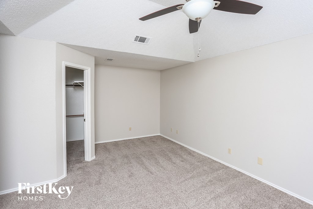 an empty room with a ceiling fan and a closet