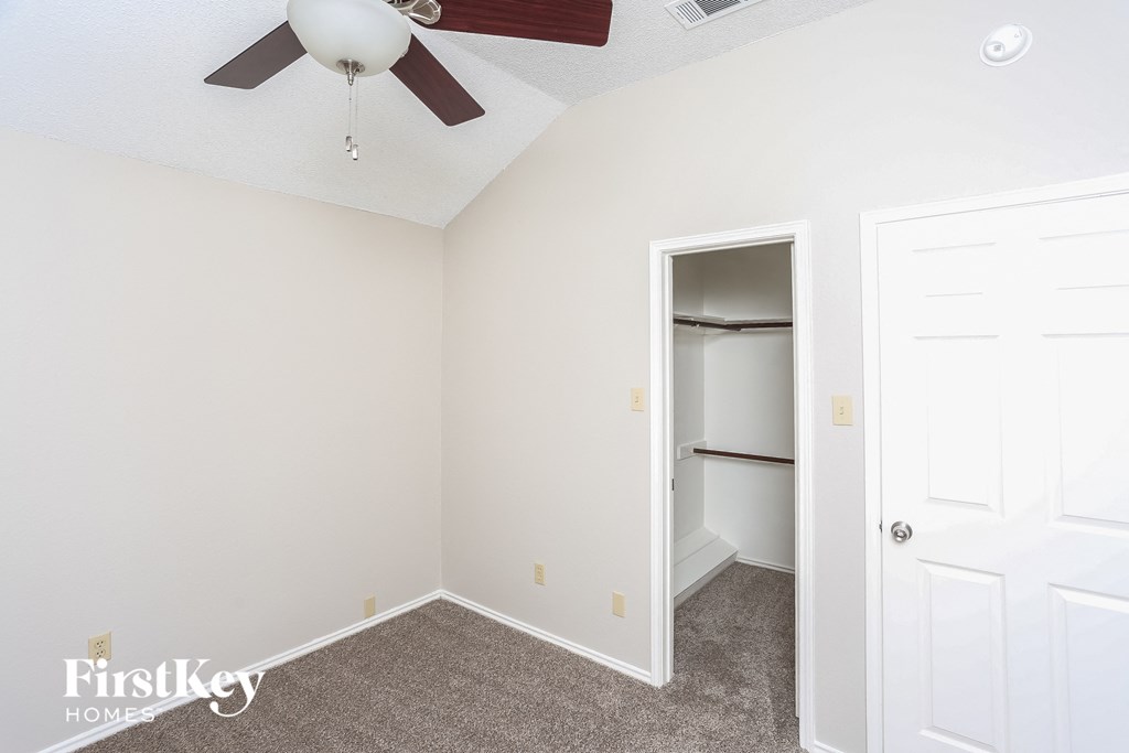 a bedroom with a closet and a ceiling fan