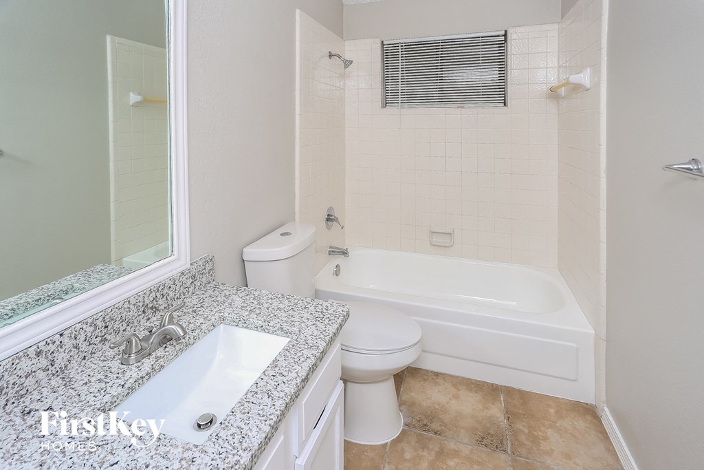 a white bathroom with a tub and a sink and a toilet