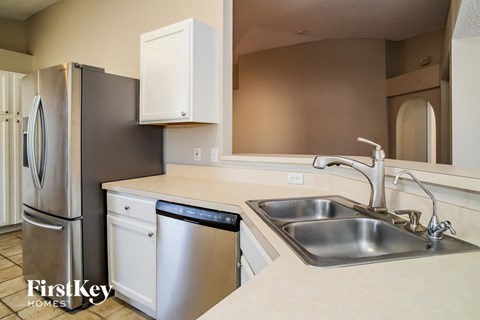 a kitchen with a sink and a dishwasher and a refrigerator