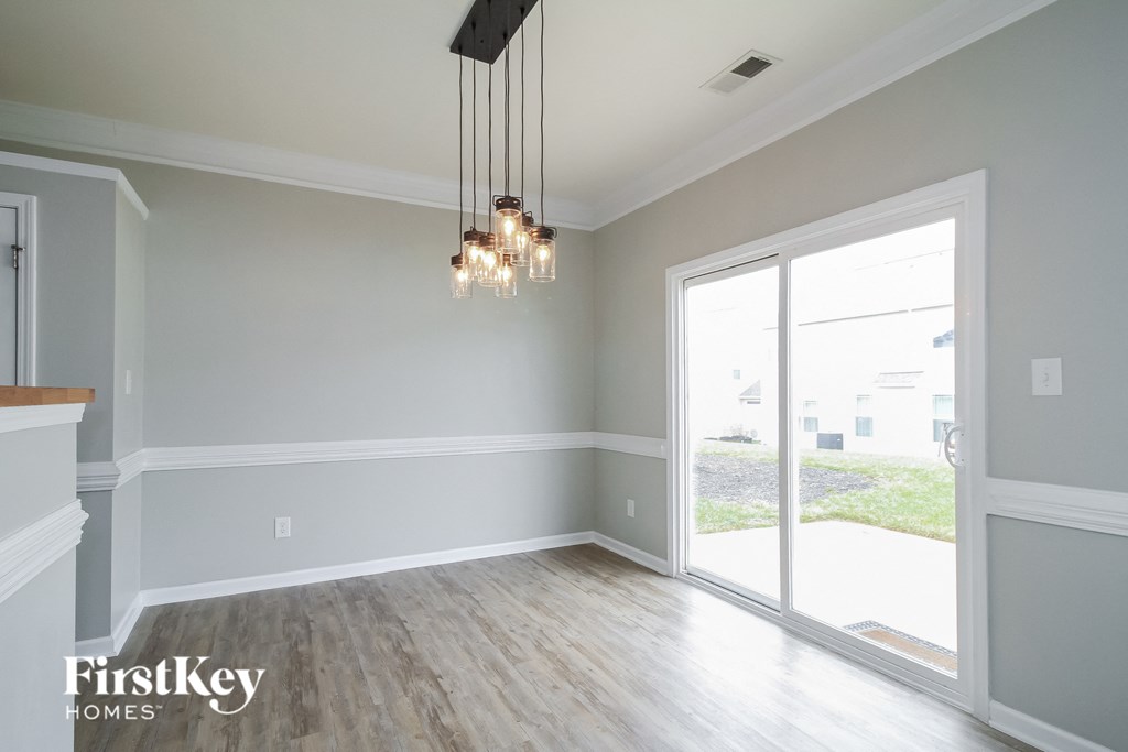 A well-lit room with a chandelier and sliding glass doors.