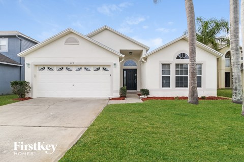 a white house with a white garage door and a lawn