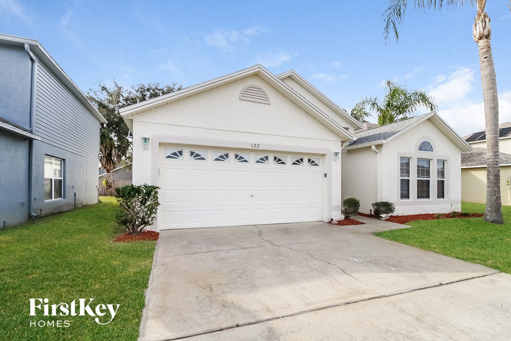 a white house with a driveway and a white garage door