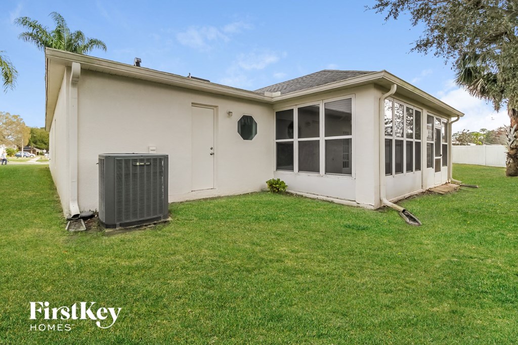 the front of a white house with a green lawn and a radiator