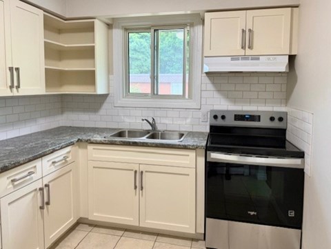 A kitchen with white cabinets and a black oven.