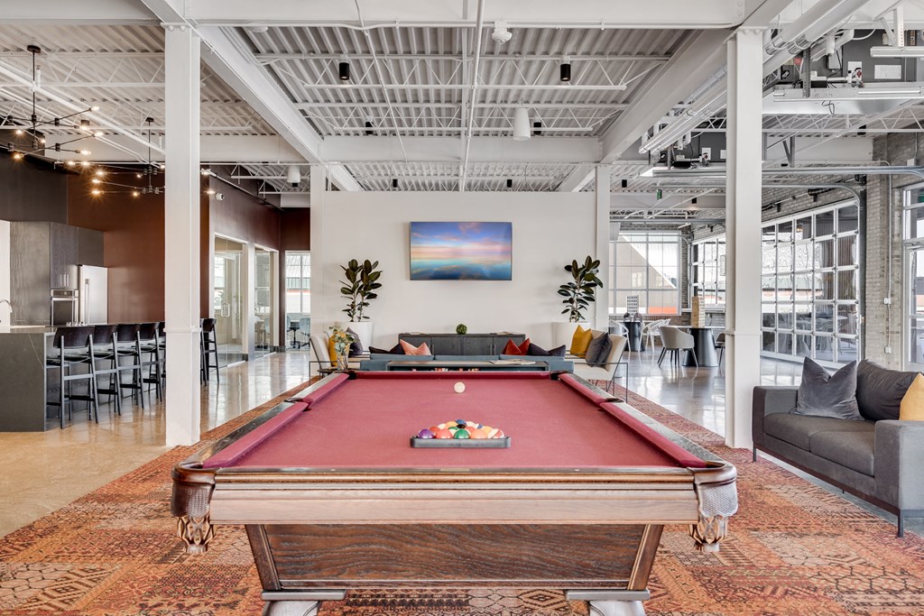 a pool table in the lobby of an office with a bar