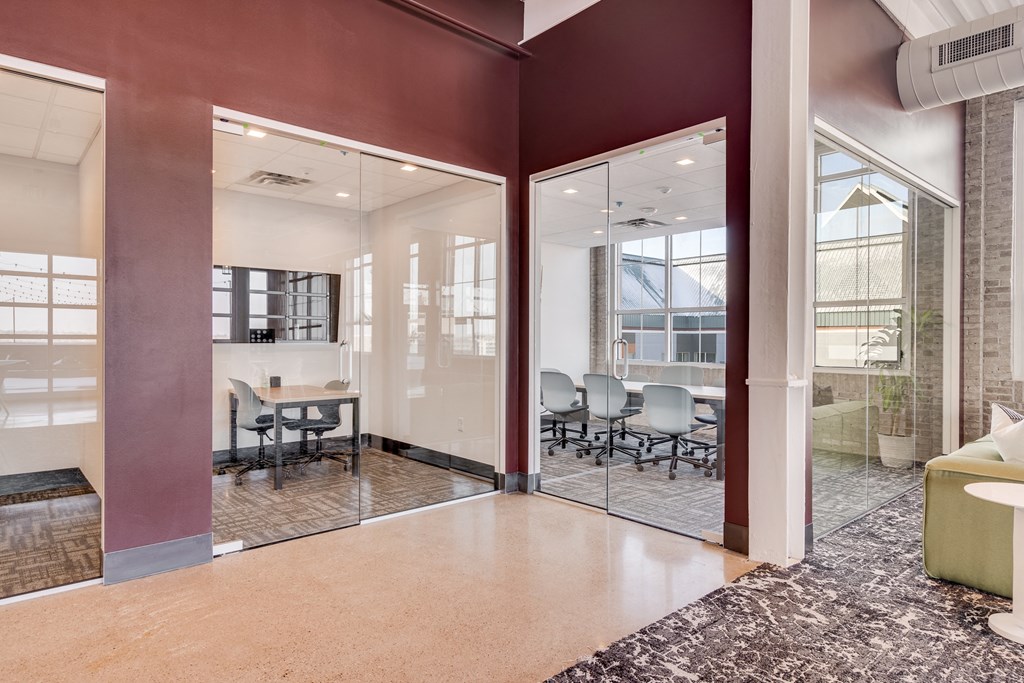 a conference room with glass doors and a table with chairs