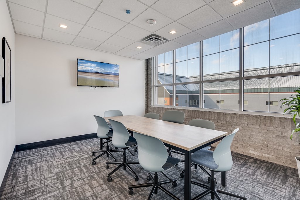 a conference room with a table and chairs and a large window