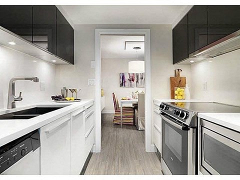 a white kitchen with a stove and a sink