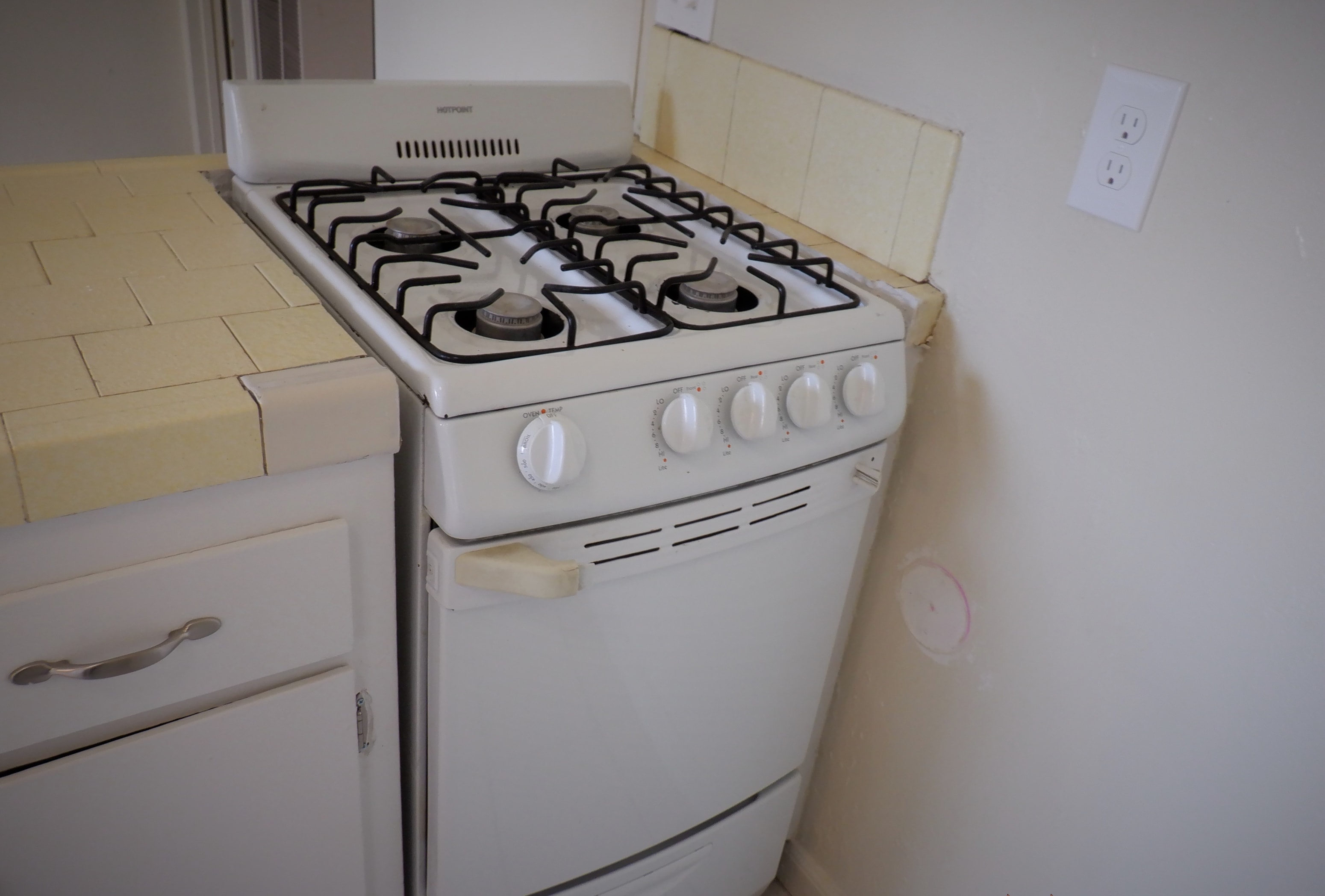 a white stove in a kitchen with white cabinets