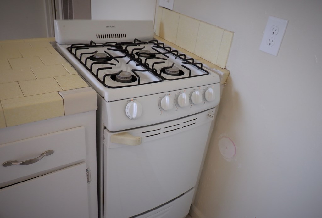 a white stove in a kitchen with white cabinets