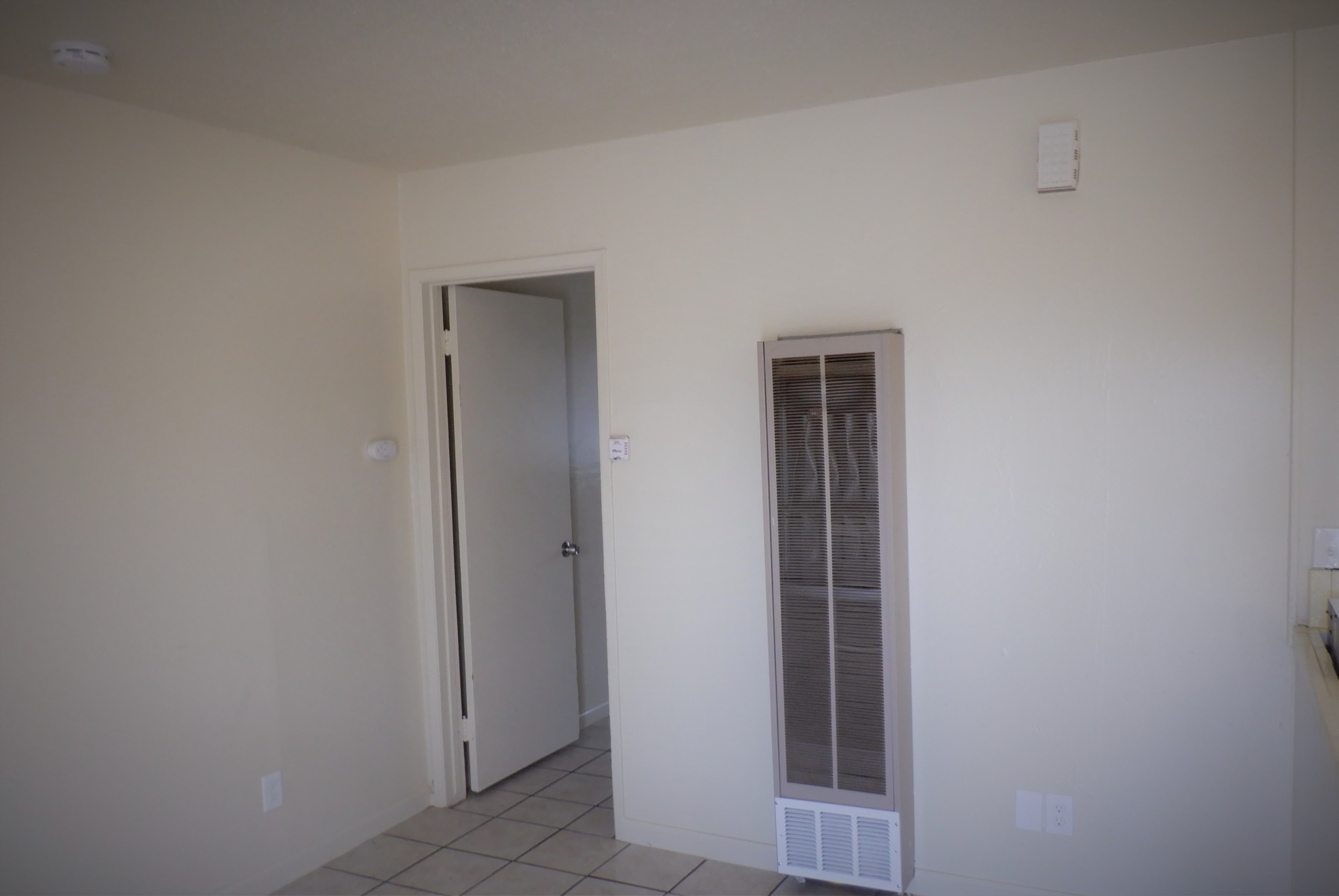 an empty room with a door and a closet