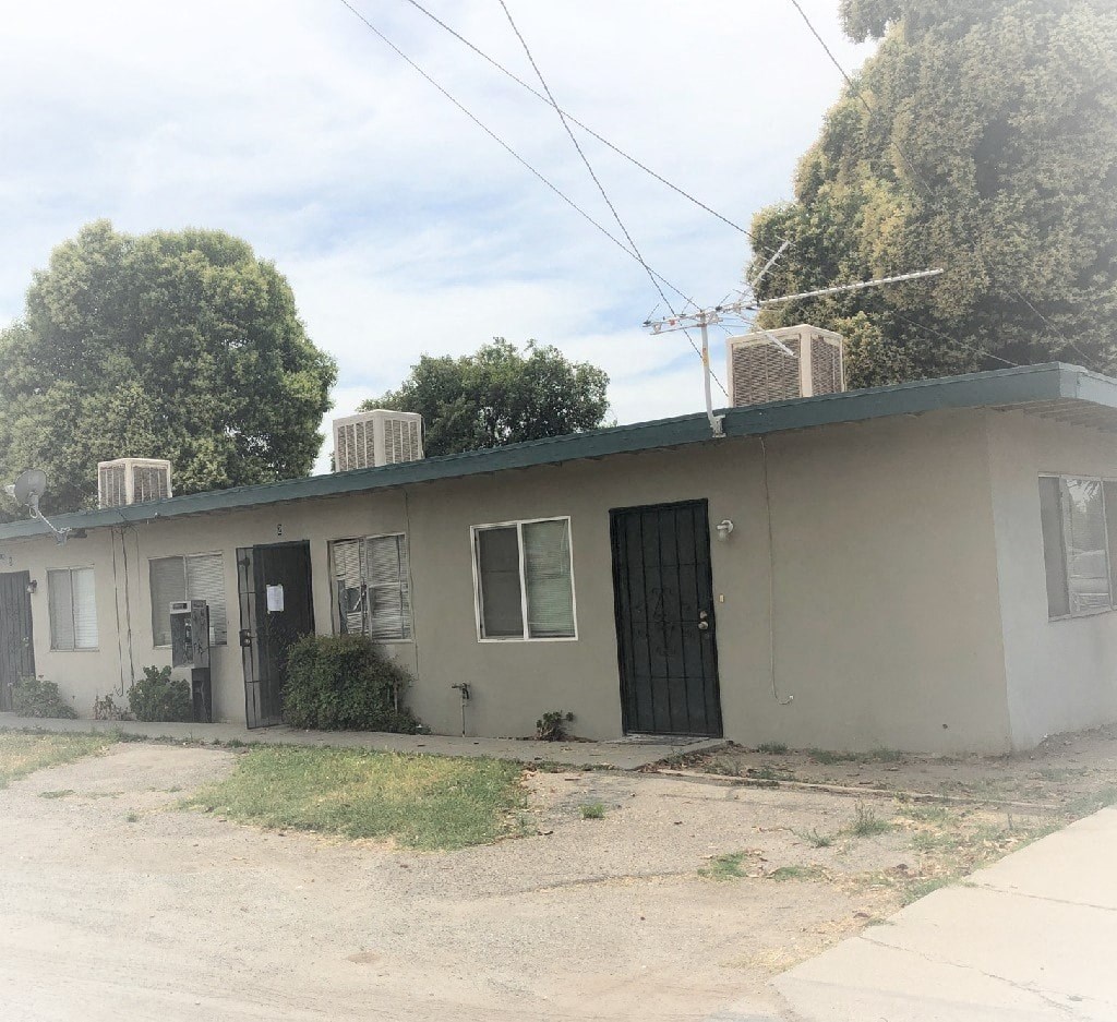 a small white house with a black door and windows