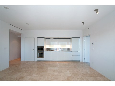 A kitchen with white cabinets and a tiled floor.