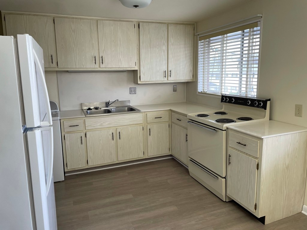 a kitchen with white cabinets and a stove and a refrigerator
