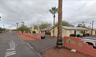 a street with houses and palm trees on the side of it