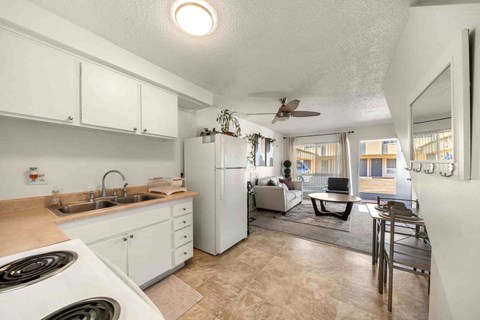 A kitchen with white cabinets and a white stove top oven.