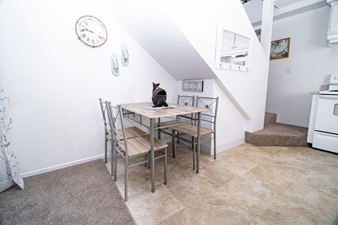 A dining room with a table and chairs.