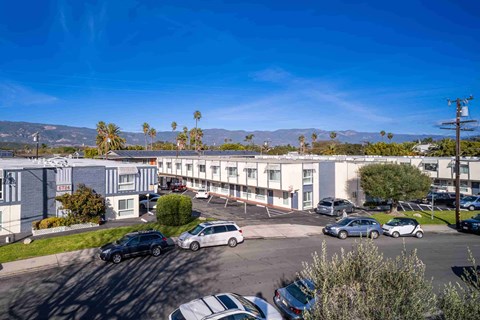 A parking lot with cars and a building in the background.