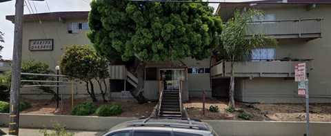 a building with stairs and a tree in front of it