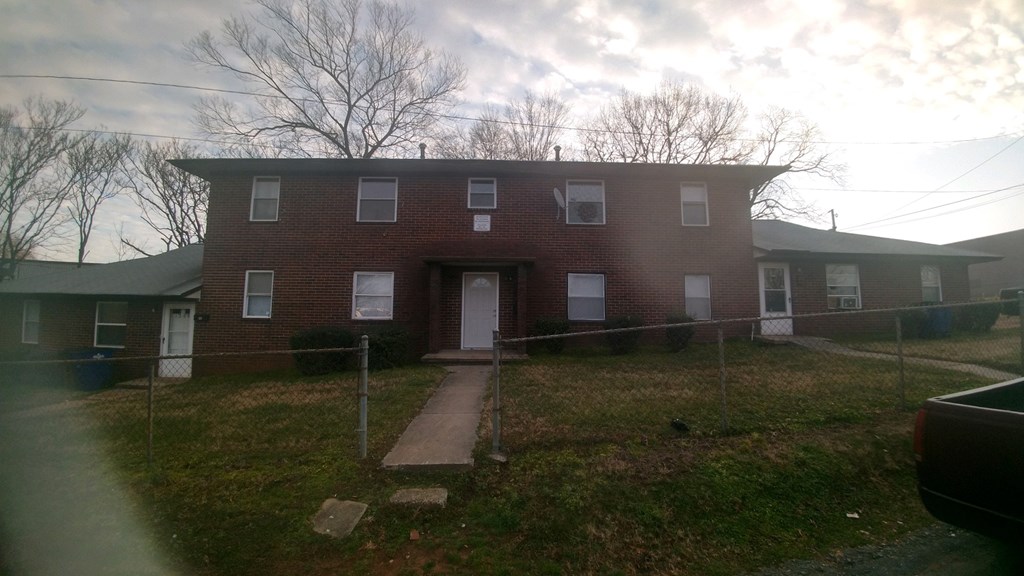a brick house with a fence in front of it