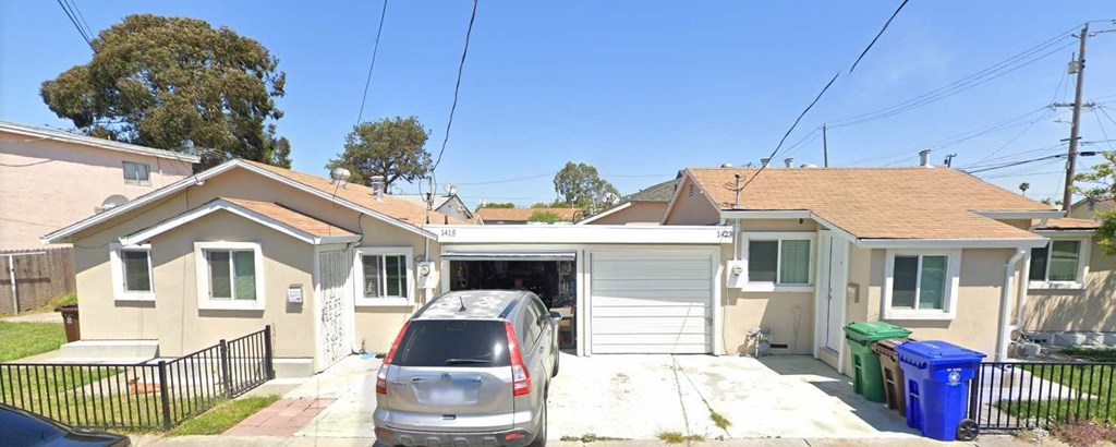 A house with a garage and a car parked in front.