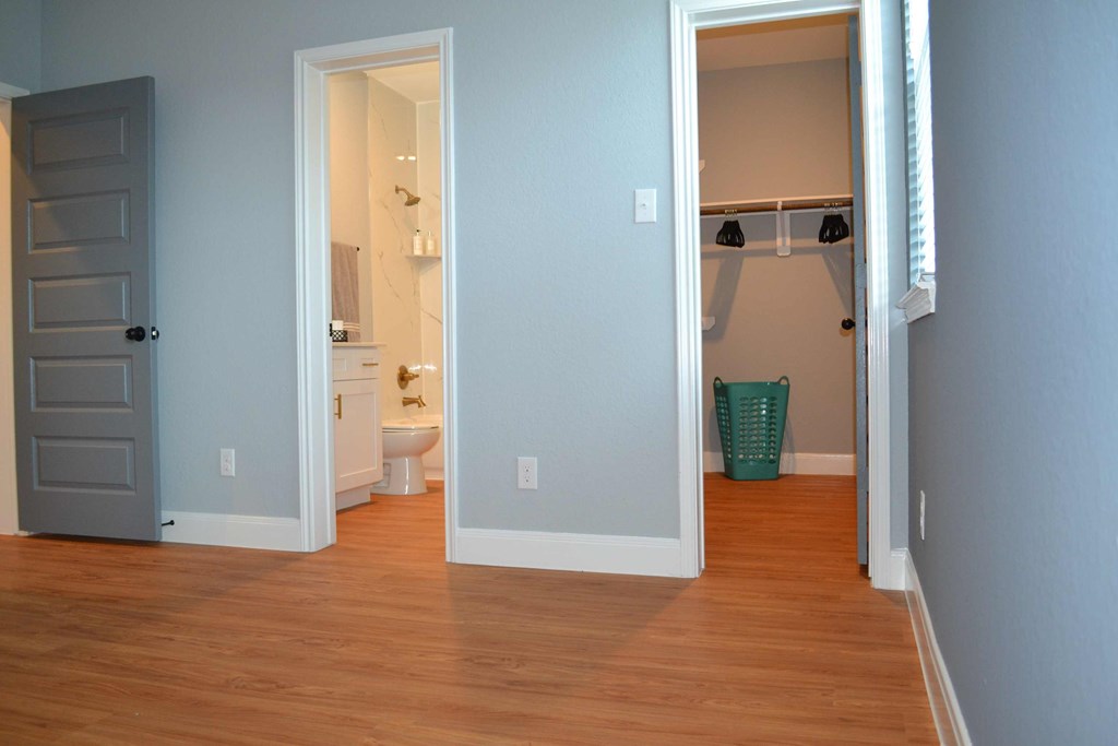 a room with a bathroom and a closet and a door open