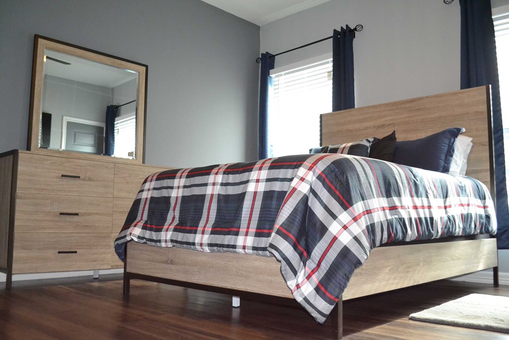 a bedroom with a bed and a dresser and a mirror