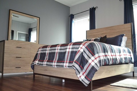 a bedroom with a bed and a dresser and a mirror