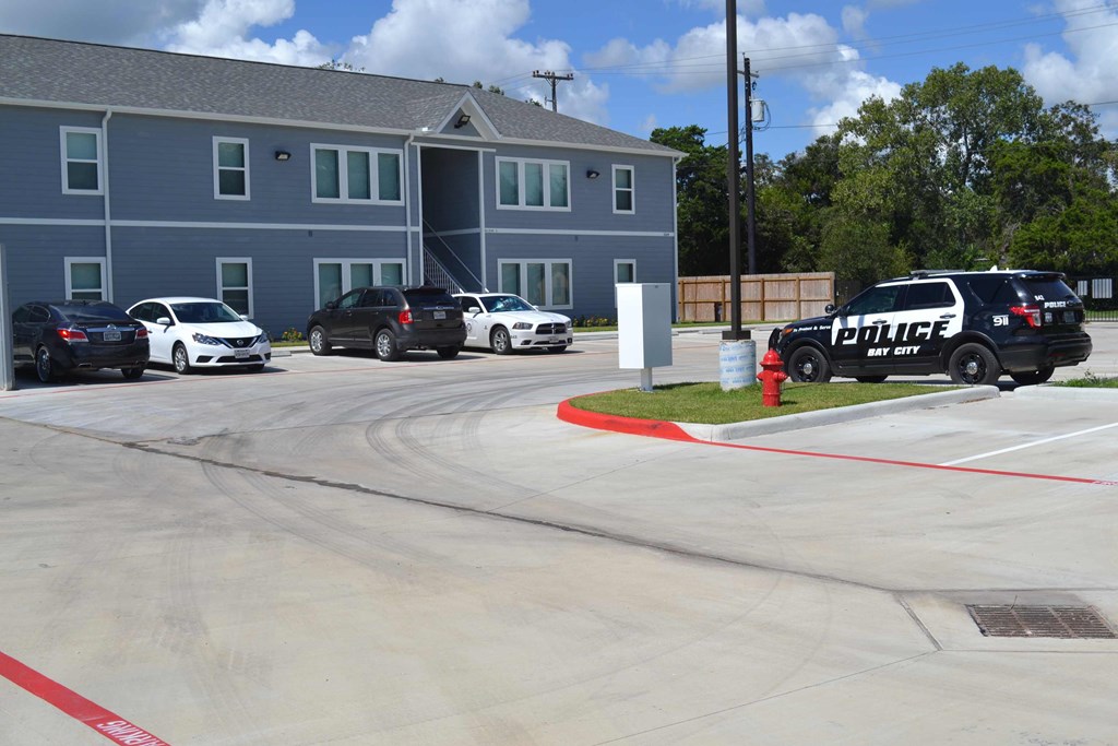 a police car parked in a parking lot in front of an apartment building