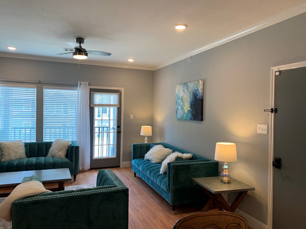 a living room with couches and a ceiling fan