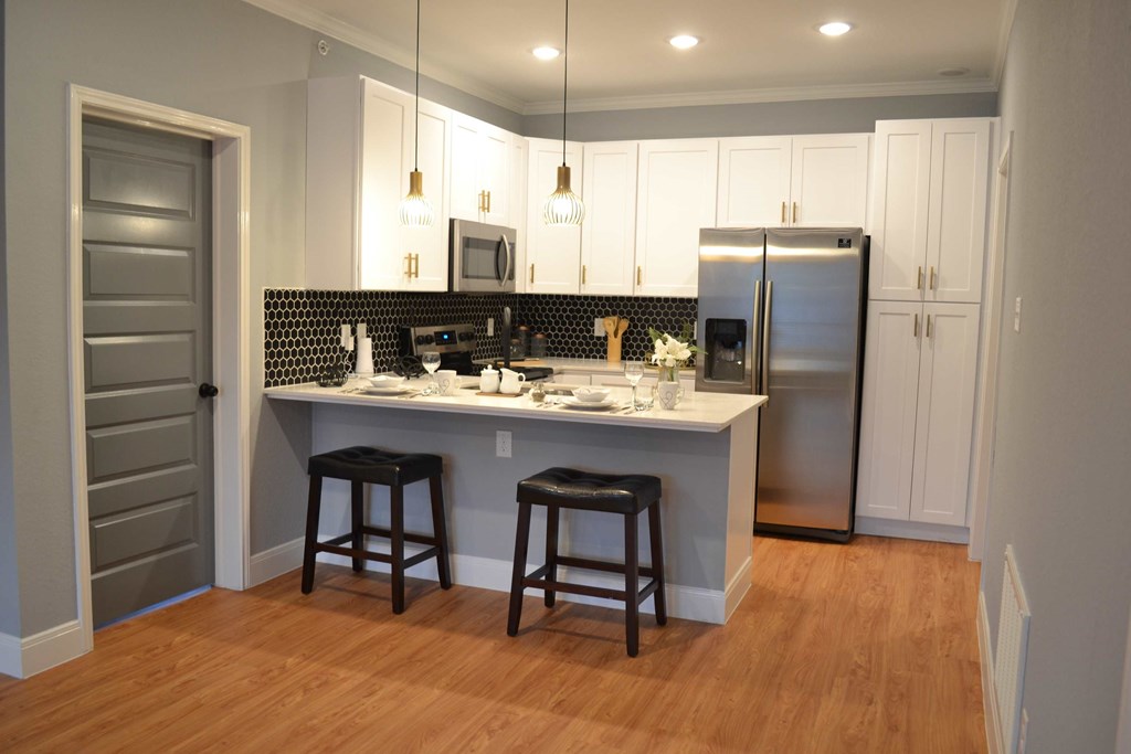 a kitchen with a island and a stainless steel refrigerator