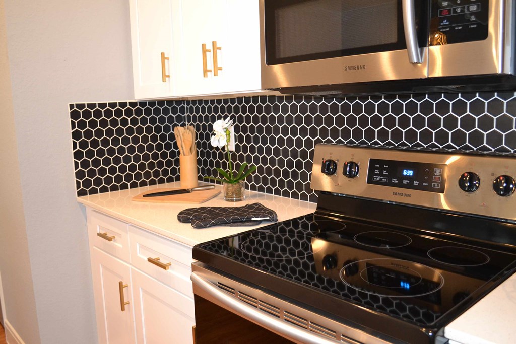 a black and white kitchen with a stove and microwave