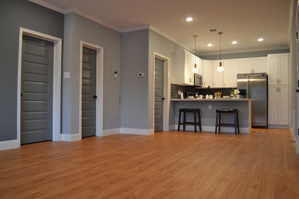 an open living room and kitchen with wood floors